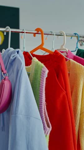 Vertical View of Apparel Clothing Displayed on Hangers in 4K Ultra HD – Fashion Retail Concept, Modern Wardrobe or Clothing Store Interior Footage

