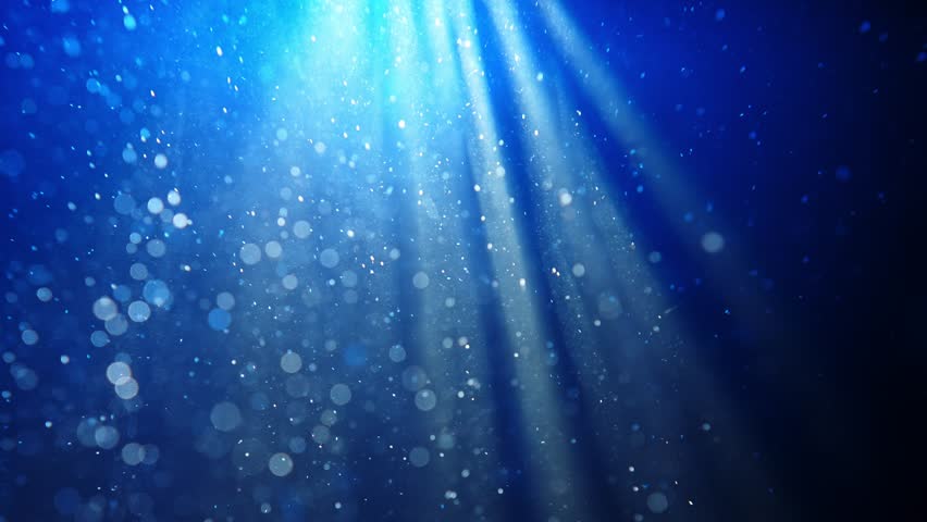 Deep underwater scene with floating particles in blue haze, creating a calm and mysterious atmosphere. Slow motion. A beam of light falling into the water highlights the floating particles. Slow