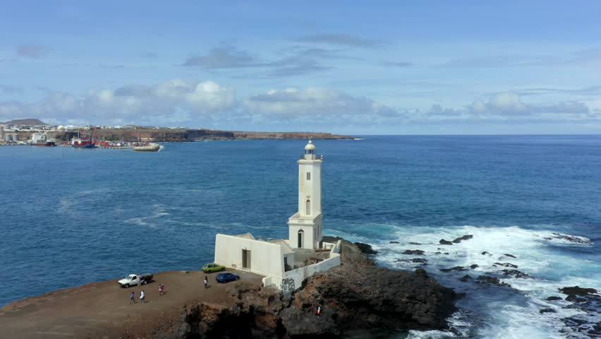 Aerial orbiting shot over Dona Maria pia Lighthouse with Praia city in Background, Santiago Island