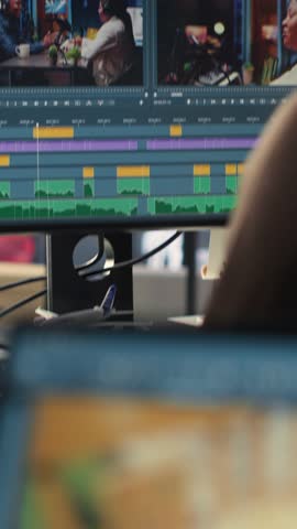 Vertical Video Video editors team working with AI chatbot and montage maker software, editing a background video and mixing clips on dual monitors. Professional man and woman in creative process