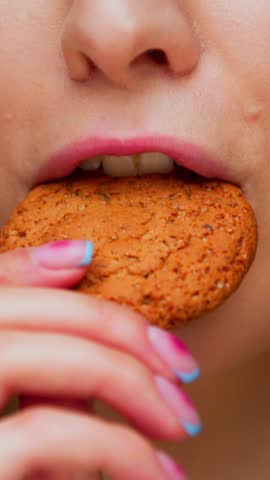 Portrait of Young Woman Eating Sweet Food on Camera. Crop Face of Playful Female Person on Diet Consuming American Cookie as Savory Lunch Snack. Sugary Fastfood in Attractive Mouth of Alone Real Human