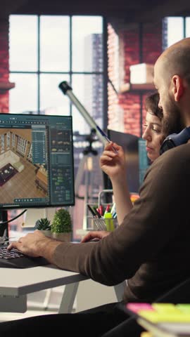 Vertical Video Designers team works on remodeling project using architectural software on PC to configure room layouts. Program allows to drag and drop elements or assets, adjusting virtual furniture