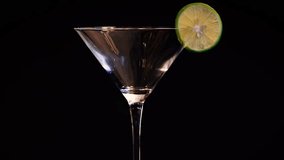 A vibrant golden liquid is poured into a martini glass with a lime slice garnish, creating dynamic splashes. - Powered by Shutterstock - Get 15% off with code: PIKWIZARD15