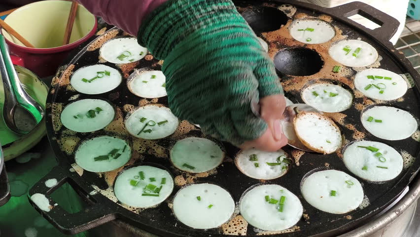Khanom Khrok is a traditional Thai coconut-rice pancake, famous for its sweet, creamy, and slightly crispy texture. It is cooked in a special cast-iron pan with small round molds