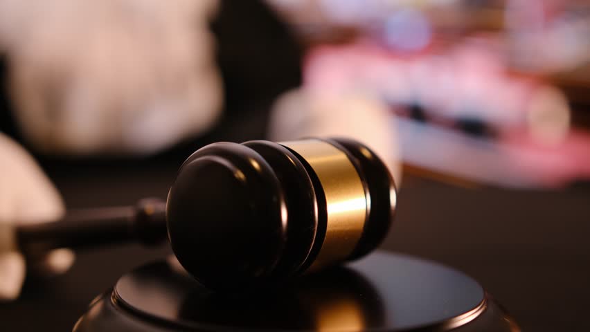 A gavel situated in a courtroom, portraying an important aspect of the legal context