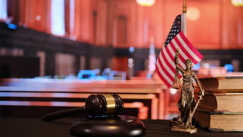 A detailed courtroom scene depicting a gavel, a statue of Lady Justice.
