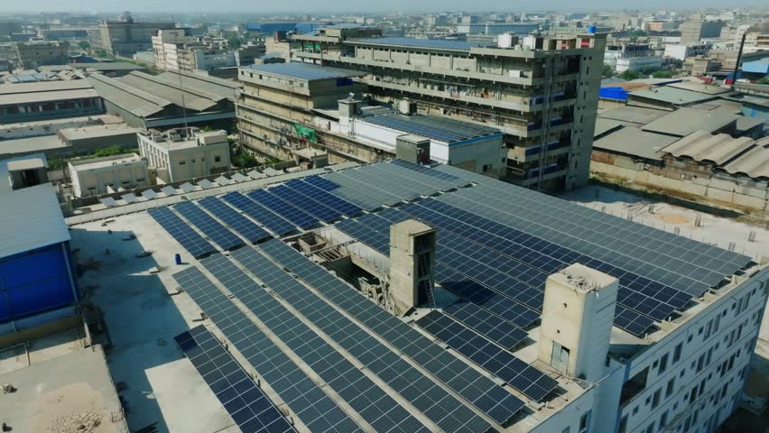 Rows of solar panels capturing sunlight on a rooftop in Karachi, contributing to sustainable energy generation