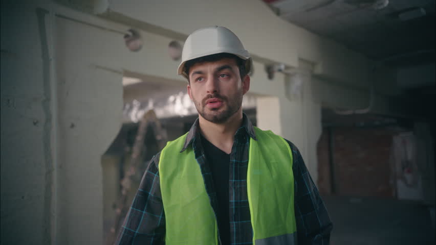 Furious irritated Caucasian workman architect foreman talking walkie talkie guy handyman inspector shouting man argument in construction male control manufacture builder screaming dissatisfaction work