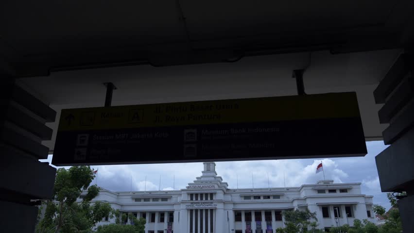 On a cloudy day, on the exterior of the Batavia Bank History Museum in Kota Tua, Jakarta, Indonesia, the text on the wall means: Bank History Museum of Indonesia.