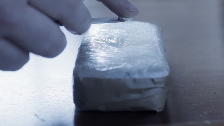 Opening wrapped block of cocaine
