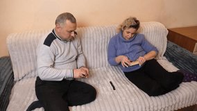 A man and a woman are playing dominoes while sitting on a sofa. - Powered by Shutterstock - Get 15% off with code: PIKWIZARD15