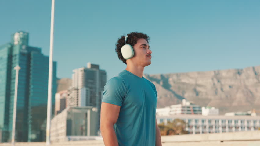 Fitness, man and getting ready with headphones in city to start running, marathon training or workout podcast. Runner, breathe or listening to music outdoor for cardio, exercise performance or health