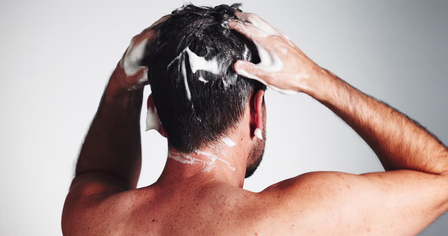 Haircare, man or hair washing with shampoo for scalp cleansing, dandruff removal or grooming routine. Back, person or self care with cosmetics product for healthy growth or shine on studio background