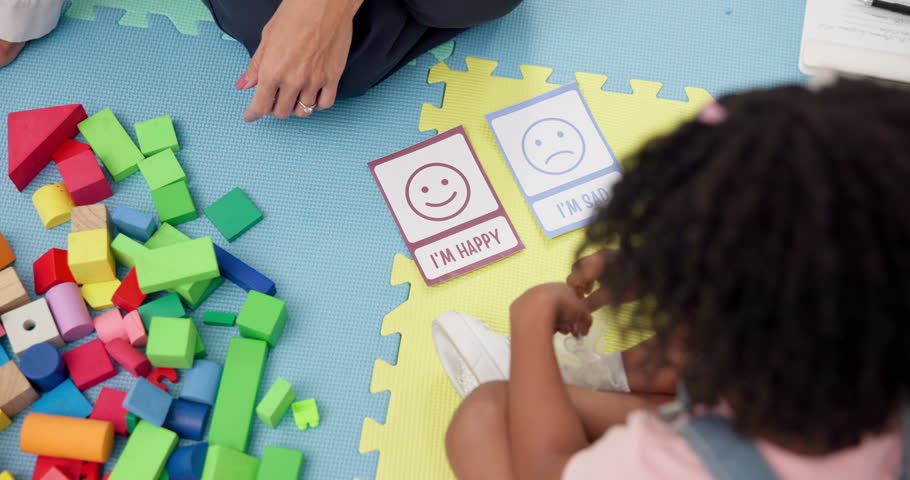 Child, girl and card with psychology for emotion, choice and point for mental health assessment from above. Hands, therapist and patient on floor with emoji, happy and sad with test at clinic