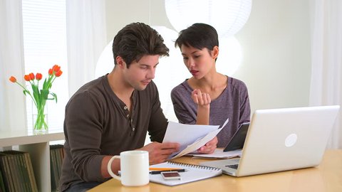 Mixed race couple paying their bills