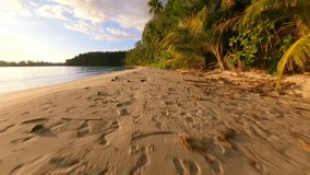 FPV drone flying low over tropical beach with golden sand, palm trees, and ocean waves at sunset on remote island in Thailand. Ideal for travel, freedom, and summer nature themes. - Powered by Shutterstock - Get 15% off with code: PIKWIZARD15
