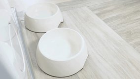 A person pours dry dog food into a ceramic bowl in a modern kitchen. The warm atmosphere reflects care for the pet's well-being and daily routine. - Powered by Shutterstock - Get 15% off with code: PIKWIZARD15