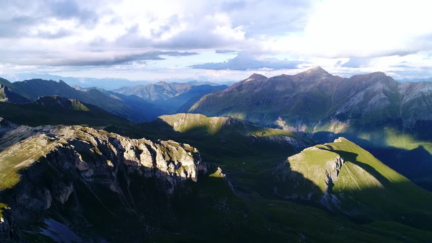 Grossglockner Alps stretch endlessly under dramatic evening skies, sunset time