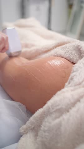 Close-up of laser hair removal on upper thigh or buttocks area, aesthetic procedure with handheld device. Smooth skin treatment in beauty clinic, professional care using modern technology.