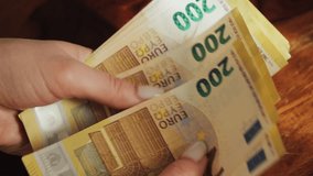 Close up of hands counting 200 euro bills. Paying with European banknotes. - Powered by Shutterstock - Get 15% off with code: PIKWIZARD15