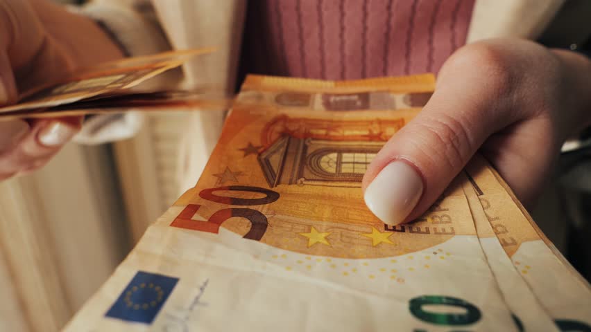 Close-up of hands, counting 50 euro notes. Payment in European banknotes. Person counting savings.