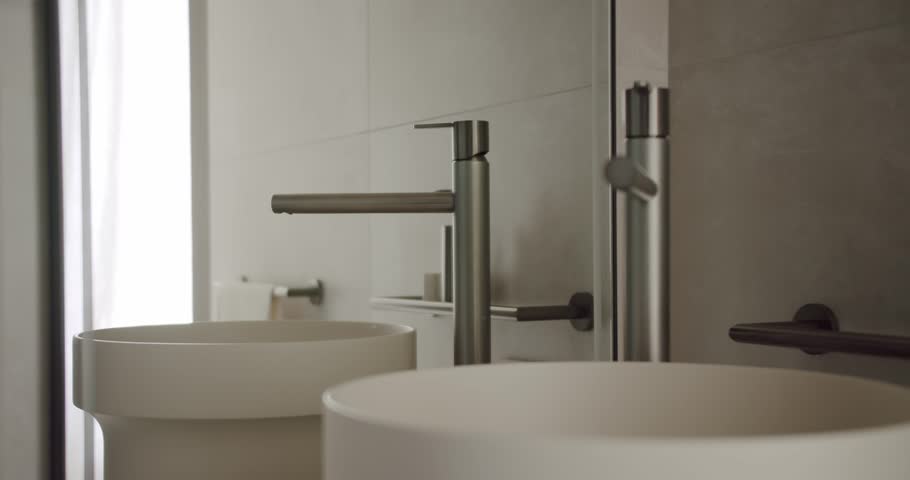 Contemporary minimalist bathroom design featuring sleek double sinks and stainless steel faucets. The elegant arrangement showcases a clean and stylish interior. Modern Minimalist Bathroom Interior