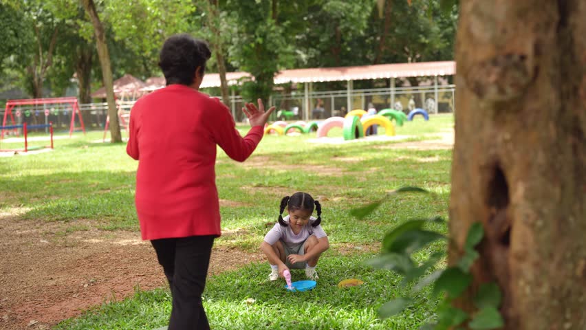 Child Playing in Outdoor Park Environment with Parent in Bright Clothing, Enjoying Fun Activities and Engaging in Quality Family Time Together