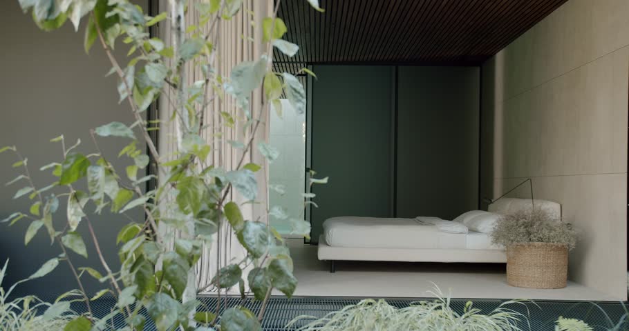 Contemporary bedroom in a minimalist style featuring sleek interiors and natural plant decorations. Perfect blend of comfort and modern aesthetics. Modern Minimalist Bedroom With Natural Elements