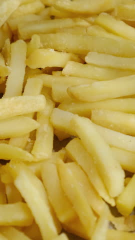 Vertical video. Fast food. Golden french fries background.