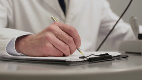 Tilt up shot of senior male ophthalmologist writing out prescription for special glasses during appointment with patient at eye care clinic - Powered by Shutterstock - Get 15% off with code: PIKWIZARD15
