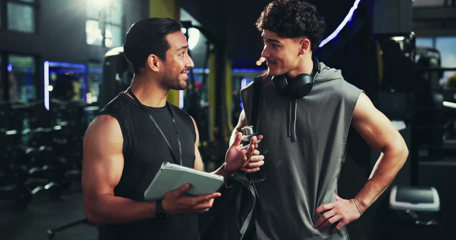 Tablet, fitness and men in gym, high five and support with challenge, exercise goals and personal trainer. People, instructor and bodybuilder with tech, hand gesture and app for progress or training