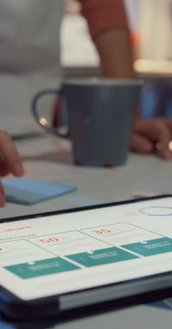 Vertical Screen : Close-up asia businesspeople meeting plan analysis statistics brainstorm header team hold tablet point graph chart employee take note at home office night. Finance strategy success.