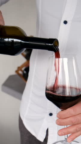 Glass of red wine in hands. Selective focus.