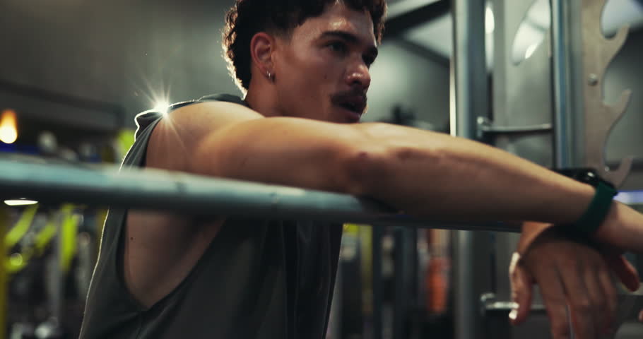 Tired man, gym and breathing with machine for rest, break or intense workout at health club. Active, male person or recovery with fatigue in fitness for weightlifting, training or physical exercise