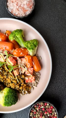 Food bowl with tofu, quinoa, broccoli and carrots, microgreens, flax and sunflower seeds