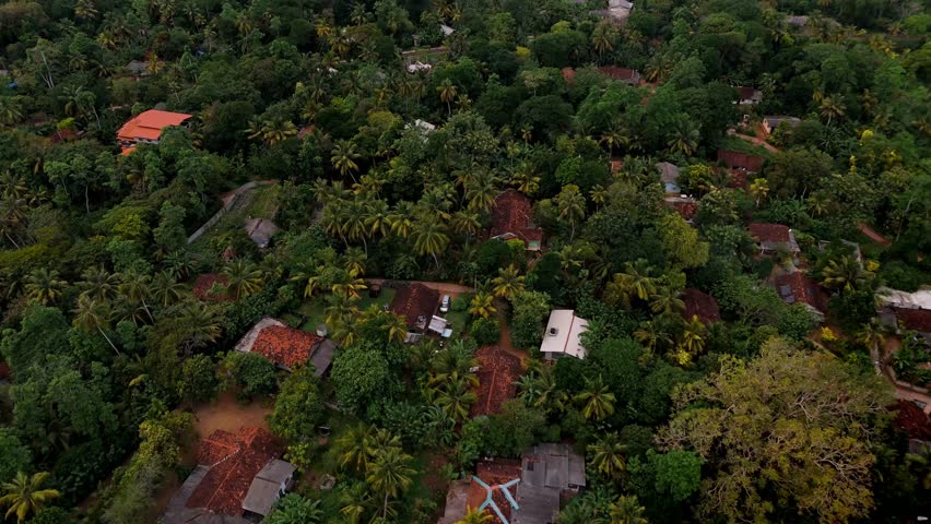 A stunning aerial drone shot capturing the coastal town of Weligama, Sri Lanka, bathed in warm golden light during sunset.