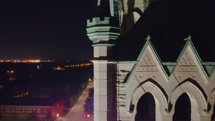 Aerial: church tower bell at night in Montreal, Quebec, Canada, orbit drone shot