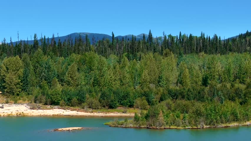 Experience an epic wilderness aerial view, showcasing majestic mountains and a pristine alpine lake, captured in breathtaking drone footage.