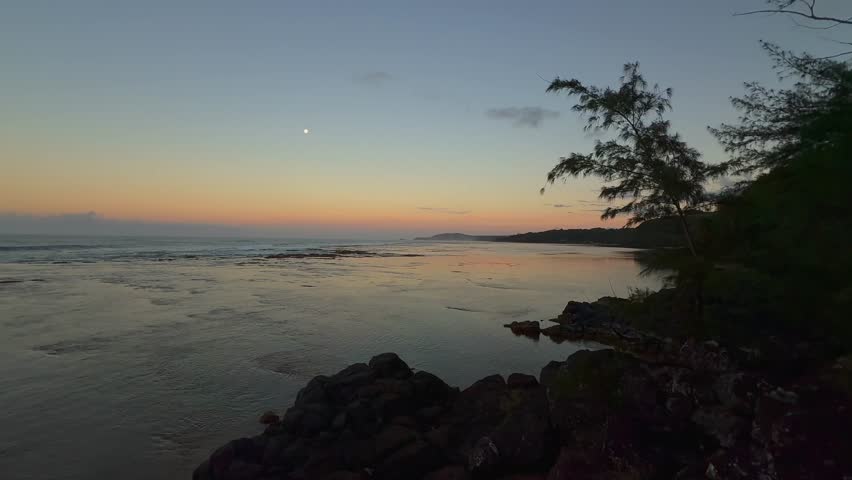 Capture the magic of sunset over the ocean in Kauai, Hawaii, with handheld 4K footage showcasing golden hour waves and the serene beauty of this tropical paradise.