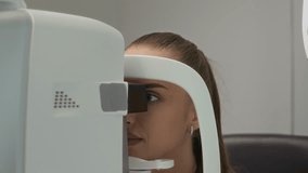 Close up on young female patient undergoing eye examination on diagnostic ophthalmic machine during appointment at ophthalmologists office of modern optometry clinic - Powered by Shutterstock - Get 15% off with code: PIKWIZARD15