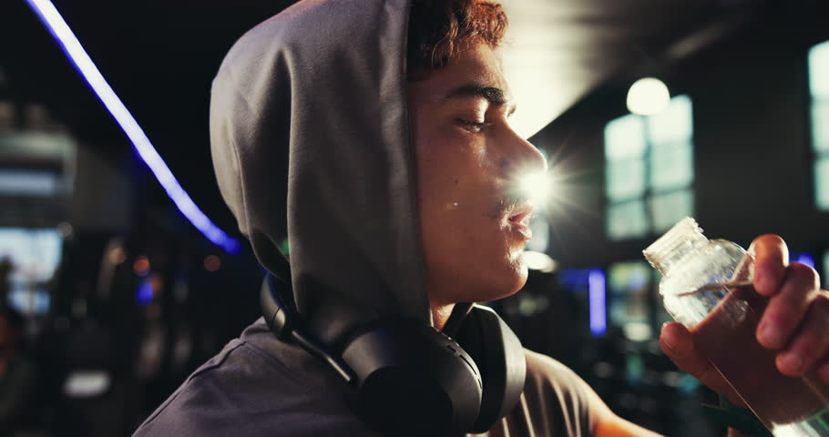 Drinking water, fitness and man in gym, thirsty and exercise with workout, resting and natural liquid. Person, bodybuilder or athlete in wellness center, intense training and challenge with hydration