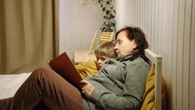 Happy old grandmother reading book to curious grandson indoors. Grandma with grandchild spending time together. Multi generation family. Kid boy and senior woman read story lying in bed. Elderly lady - Powered by Shutterstock - Get 15% off with code: PIKWIZARD15