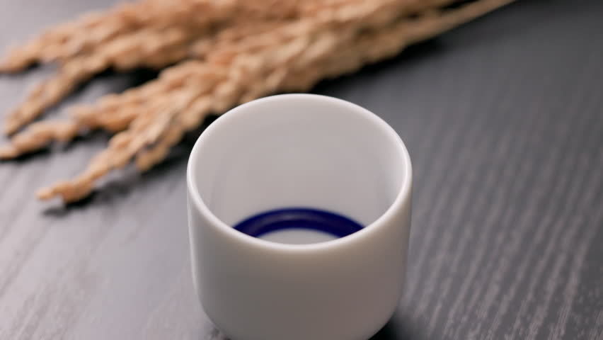 Sake being poured into an ochoko(traditional Japanese sake cup)