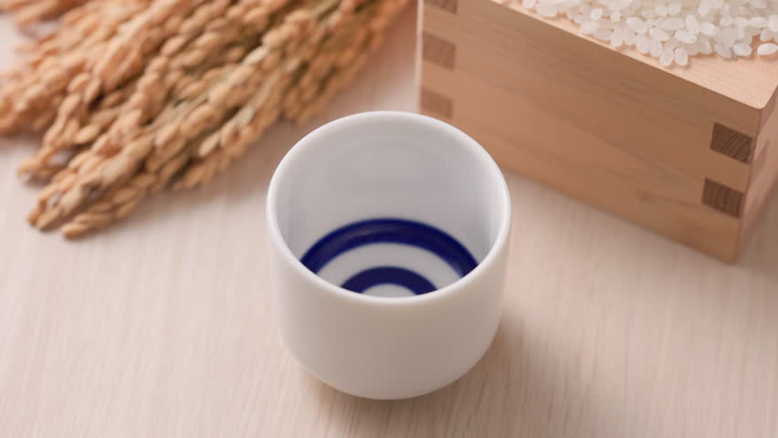 Sake being poured into an ochoko(traditional Japanese sake cup)
