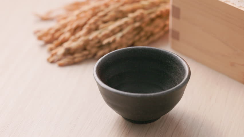 Sake being poured into an ochoko(traditional Japanese sake cup)