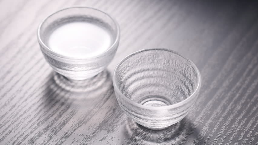 Sake being poured into an ochoko(traditional Japanese sake cup)