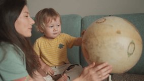 Boy Playing With Globe with mother. Little kid Looking at the sphere, have happy time with mommy. Exploring World, Learning. Dreaming About Future Save of Our Planet. Concept of family and childhood. - Powered by Shutterstock - Get 15% off with code: PIKWIZARD15