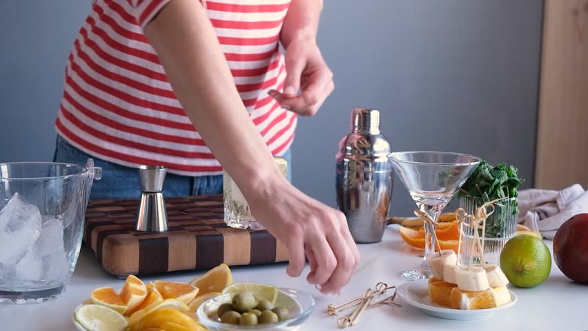 woman making alcohol cocktail in home kitchen