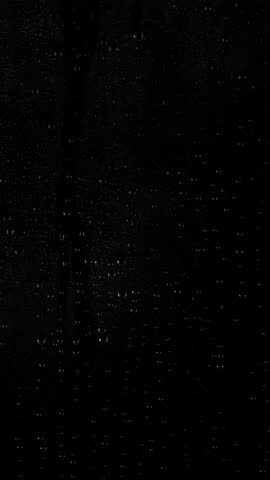 Vertical close-up rain water drops, raindrops texture on black window background. 4k footage