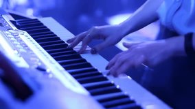 Hands playing on synthesizer keyboard under blue light. Musician performing on stage or in studio. Close-up of fingers on keys of musical instrument. - Powered by Shutterstock - Get 15% off with code: PIKWIZARD15